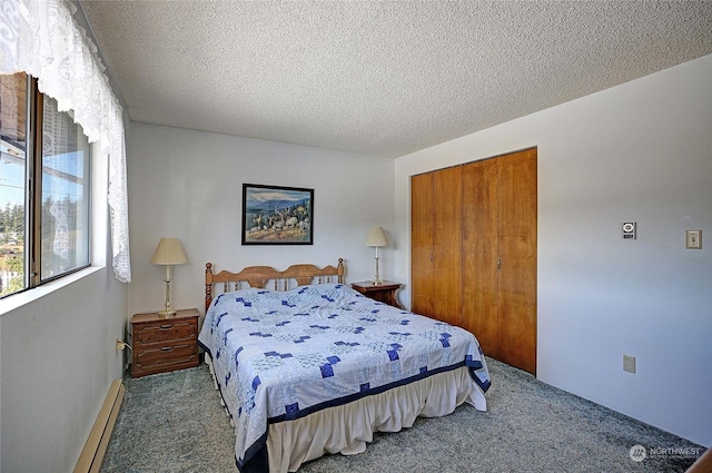 carpeted bedroom featuring baseboard heating, a closet, and a textured ceiling