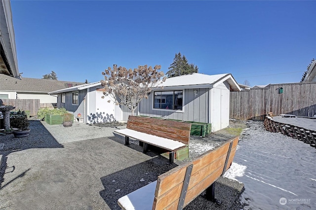 back of house with a storage unit and a patio area