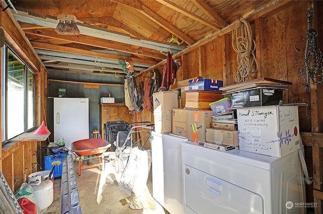 basement with water heater, washer / dryer, and white refrigerator