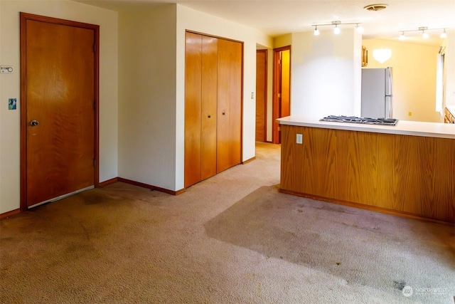 interior space featuring light colored carpet and stainless steel appliances