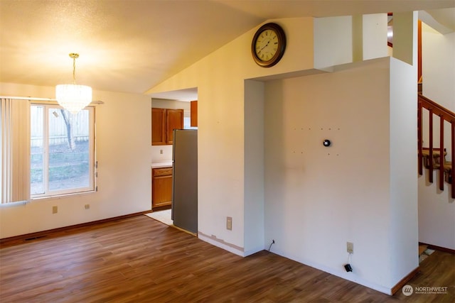 interior space with hardwood / wood-style flooring, vaulted ceiling, and a notable chandelier