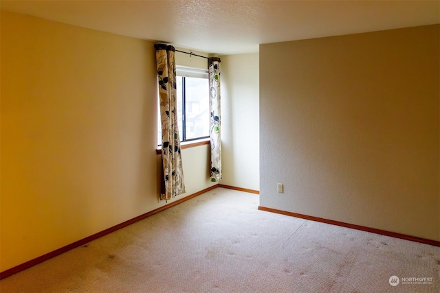 carpeted spare room featuring a textured ceiling