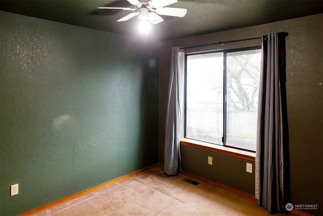 carpeted spare room featuring ceiling fan