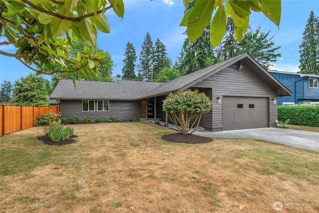 view of front of home featuring driveway, a front lawn, an attached garage, and fence