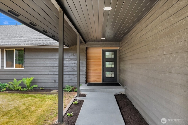 doorway to property with a shingled roof