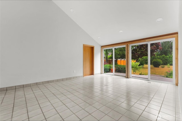 empty room featuring light tile patterned floors and high vaulted ceiling