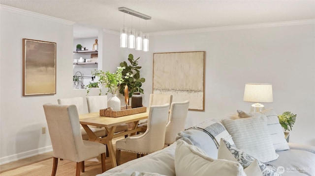 dining area with crown molding, baseboards, and wood finished floors