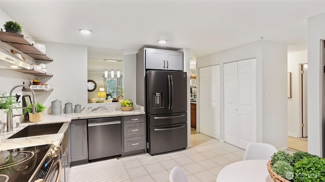 kitchen featuring light stone counters, open shelves, gray cabinetry, fridge with ice dispenser, and dishwasher