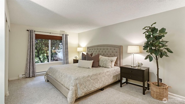 bedroom featuring a baseboard heating unit, light carpet, a textured ceiling, and baseboards