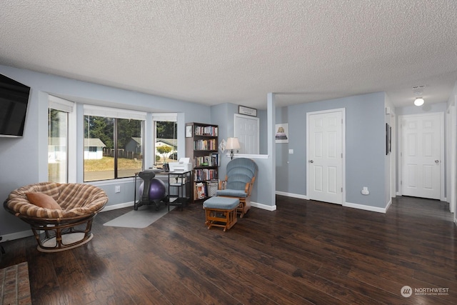 living area featuring dark hardwood / wood-style floors and a textured ceiling