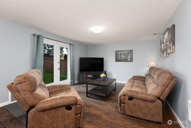 living room with dark wood-type flooring, french doors, and a textured ceiling