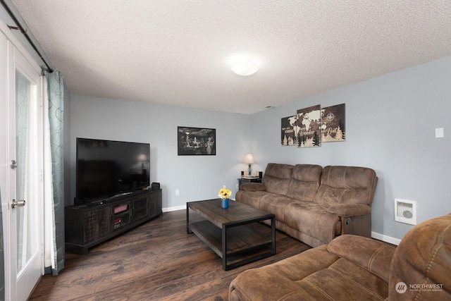 living room with dark wood-type flooring and a textured ceiling