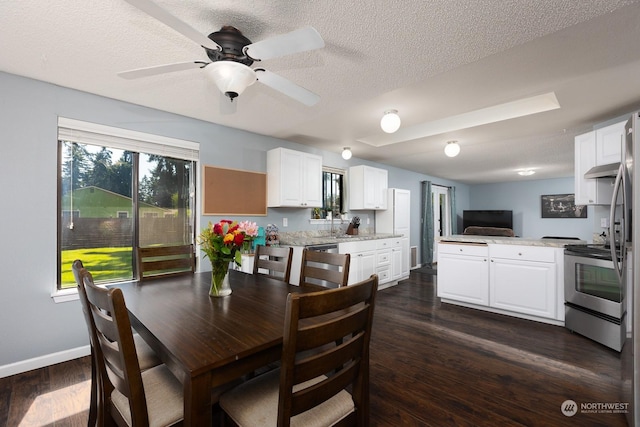 dining area with ceiling fan, a textured ceiling, and dark hardwood / wood-style flooring