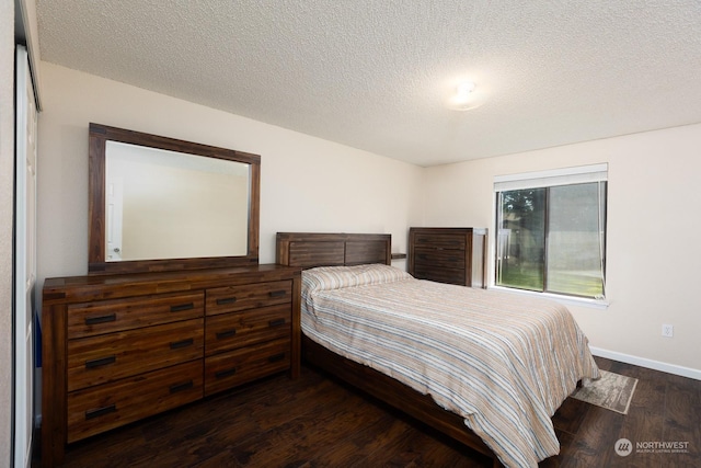 bedroom featuring dark hardwood / wood-style flooring and a textured ceiling