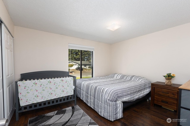 bedroom featuring dark wood-type flooring, a closet, and a textured ceiling