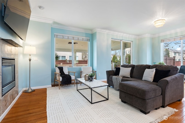 living room featuring a tiled fireplace, a wealth of natural light, and hardwood / wood-style floors