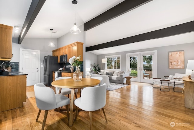 dining room featuring french doors, vaulted ceiling with beams, sink, and light wood-type flooring