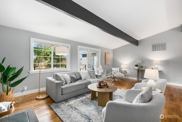 living room featuring hardwood / wood-style flooring, french doors, and vaulted ceiling with beams