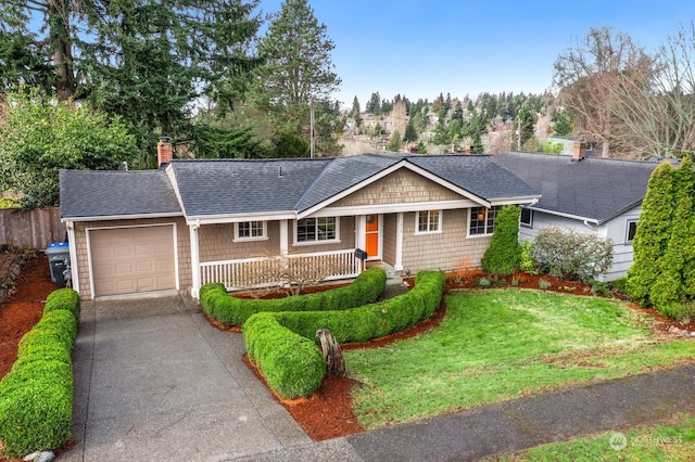 single story home featuring a garage, a front yard, and covered porch