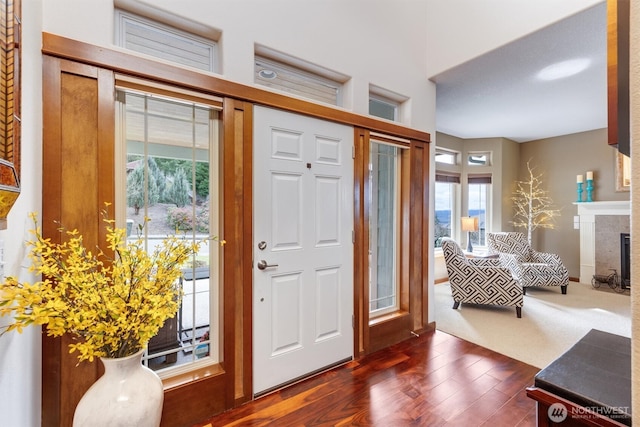 entryway with dark wood-style floors and a premium fireplace