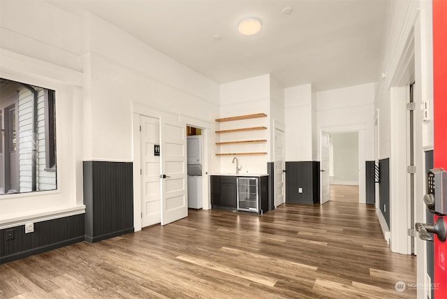 unfurnished living room featuring indoor bar, dark wood-type flooring, and beverage cooler