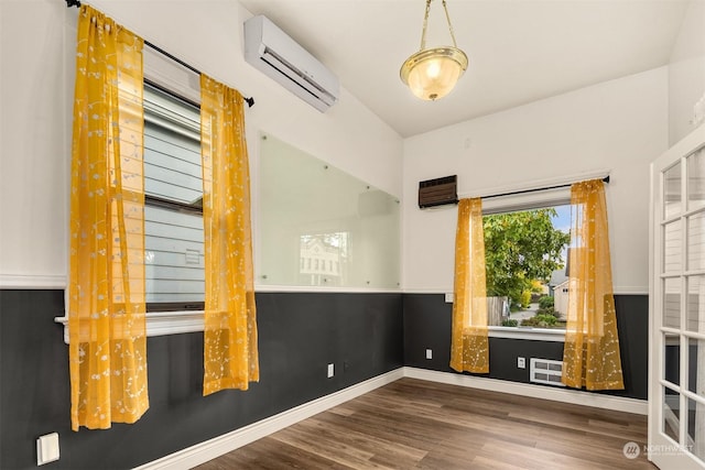 empty room featuring hardwood / wood-style floors and a wall unit AC