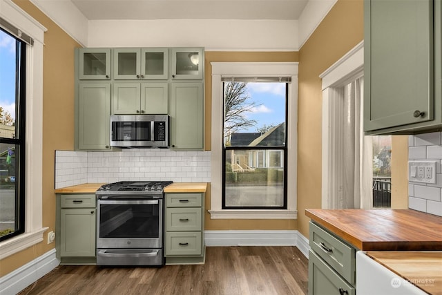 kitchen with appliances with stainless steel finishes, wooden counters, and green cabinetry