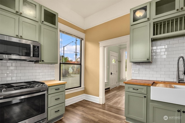 kitchen featuring sink, green cabinetry, wooden counters, dark hardwood / wood-style floors, and stainless steel appliances