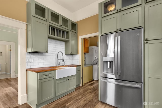 kitchen featuring dark hardwood / wood-style floors, wood counters, sink, stainless steel fridge, and green cabinets