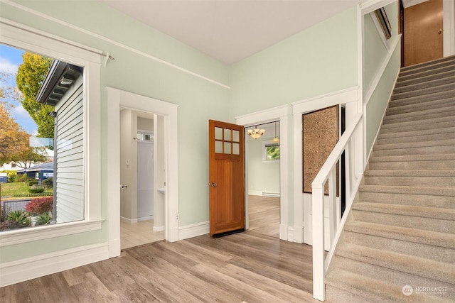 interior space with a notable chandelier, hardwood / wood-style flooring, and a healthy amount of sunlight