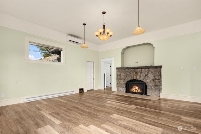 unfurnished living room featuring an AC wall unit, a notable chandelier, a fireplace, hardwood / wood-style floors, and a baseboard heating unit