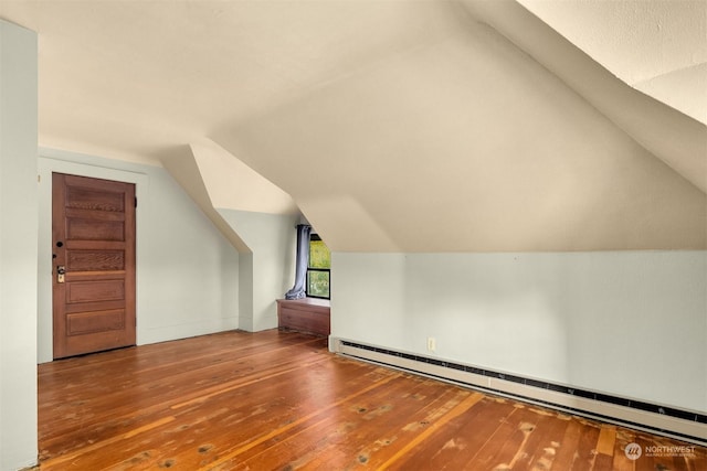 additional living space with lofted ceiling, wood-type flooring, and baseboard heating