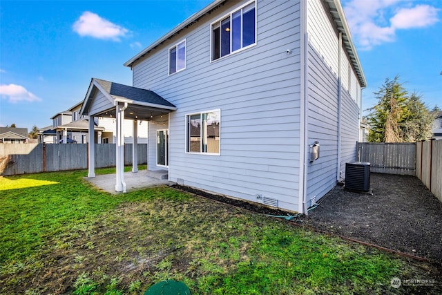 rear view of house featuring a yard, central AC unit, and a patio