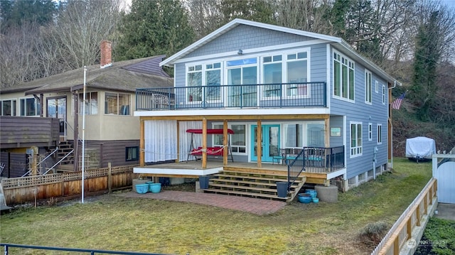 back of house featuring a wooden deck and a yard