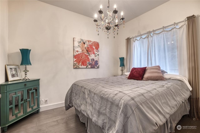 bedroom with wood-type flooring and a notable chandelier