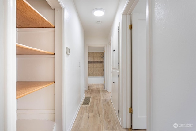 corridor with light hardwood / wood-style flooring