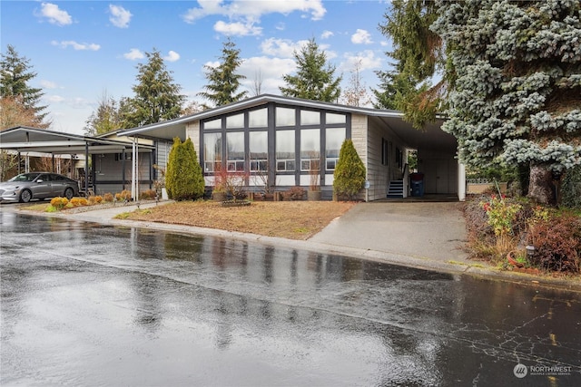 view of front of house with a carport and a sunroom