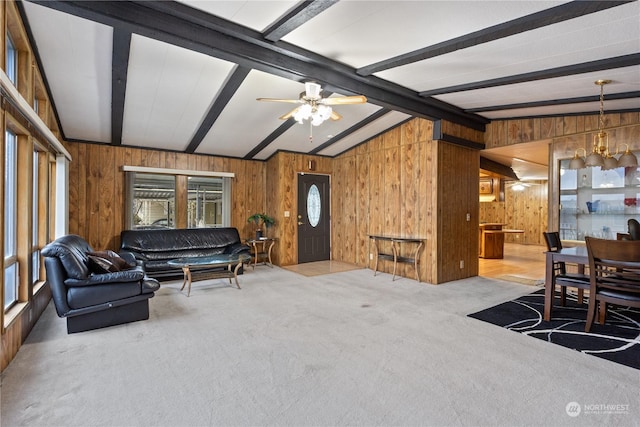 carpeted living room featuring wooden walls, lofted ceiling with beams, and ceiling fan