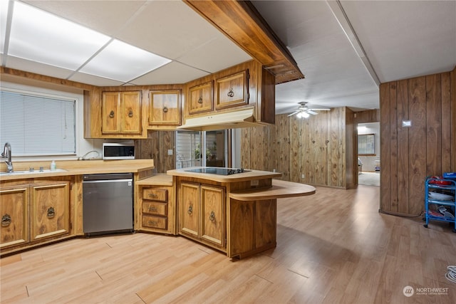 kitchen featuring dishwasher, sink, light hardwood / wood-style floors, and kitchen peninsula