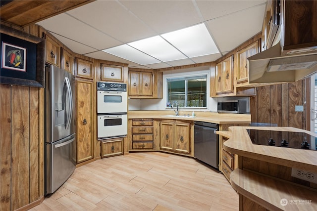 kitchen featuring a paneled ceiling, sink, light hardwood / wood-style flooring, and black appliances