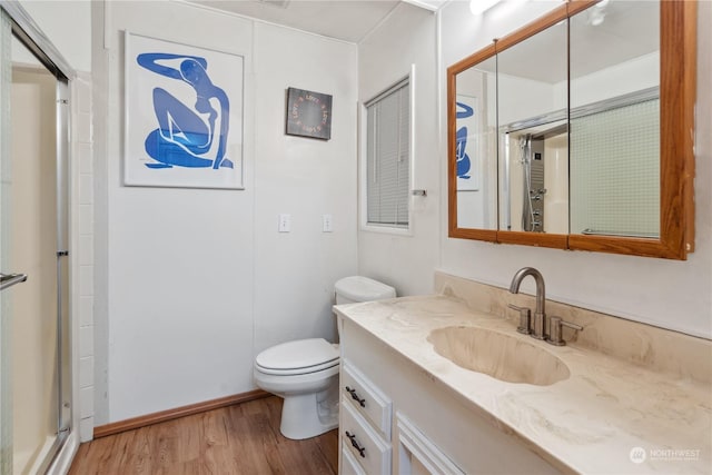 bathroom featuring vanity, hardwood / wood-style floors, an enclosed shower, and toilet