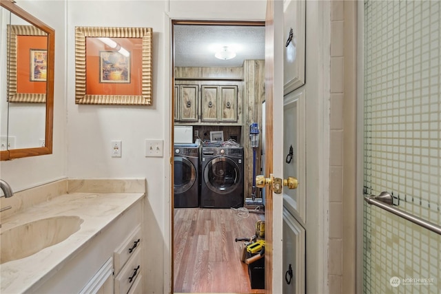 bathroom with hardwood / wood-style flooring, vanity, and separate washer and dryer