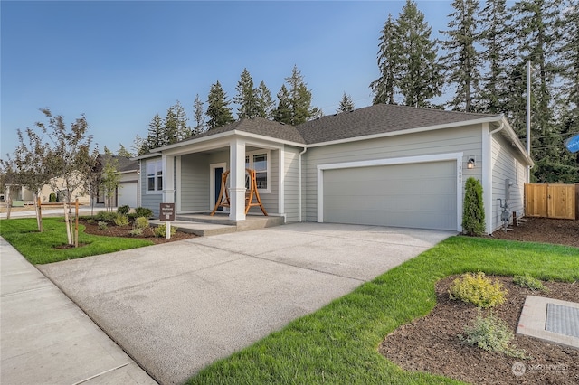 single story home with a garage, a front lawn, and covered porch