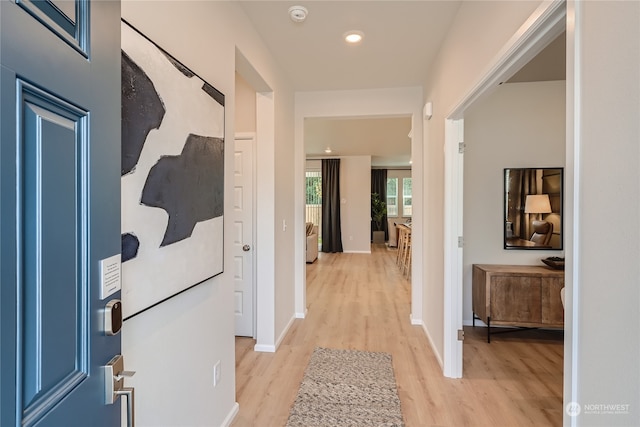 hallway with light hardwood / wood-style floors