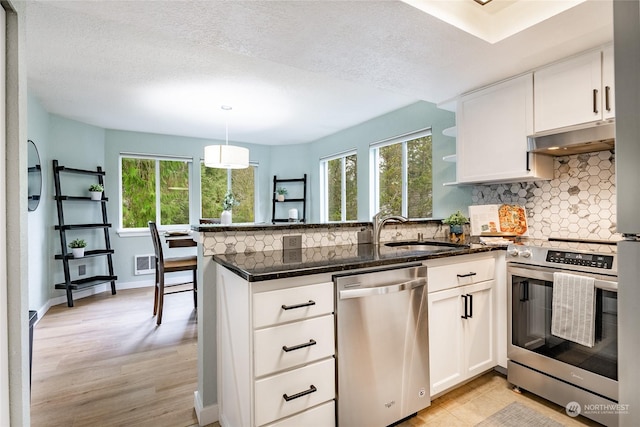 kitchen with white cabinetry, sink, hanging light fixtures, and appliances with stainless steel finishes