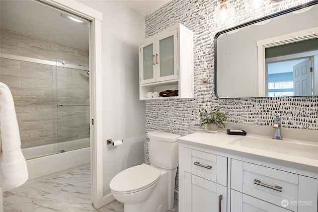 full bathroom featuring vanity, toilet, and combined bath / shower with glass door