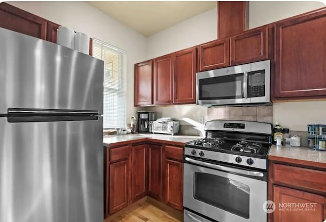 kitchen featuring stainless steel appliances and tasteful backsplash