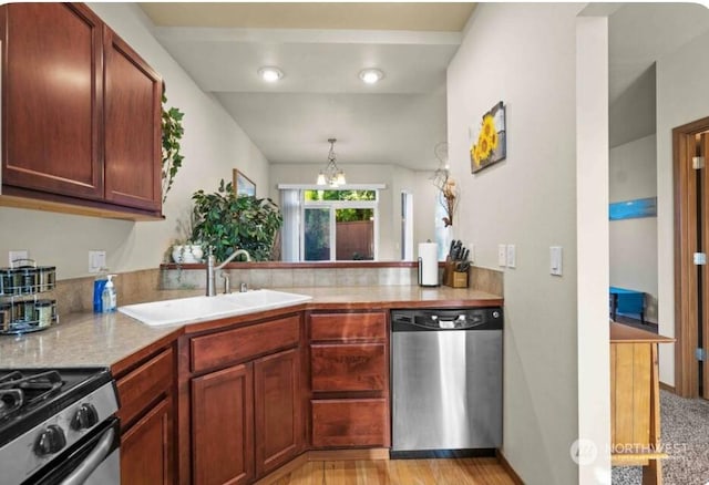 kitchen with pendant lighting, sink, stainless steel appliances, and kitchen peninsula