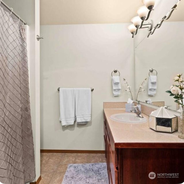 bathroom with tile patterned floors, a chandelier, and vanity