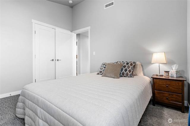 bedroom with dark carpet and a closet